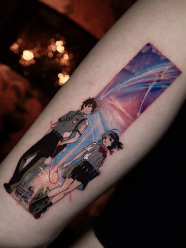Anime Tattoo: farbige Szene zweier Figuren unter einem Kometenhimmel auf dem Unterarm