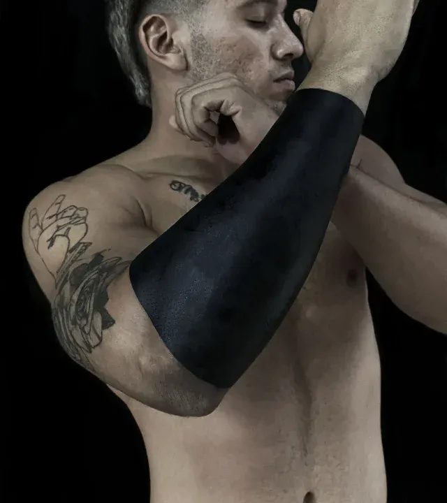 Blackwork- und Blackout-Tattoo: flächig ausgefüllter schwarzer Unterarm
