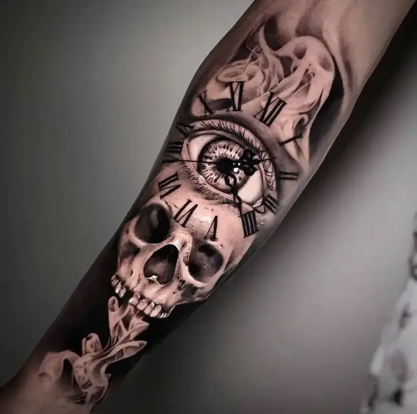 Black-and-Grey Tattoo: Totenkopf, Auge und römische Uhr in Rauchschwaden auf dem Unterarm