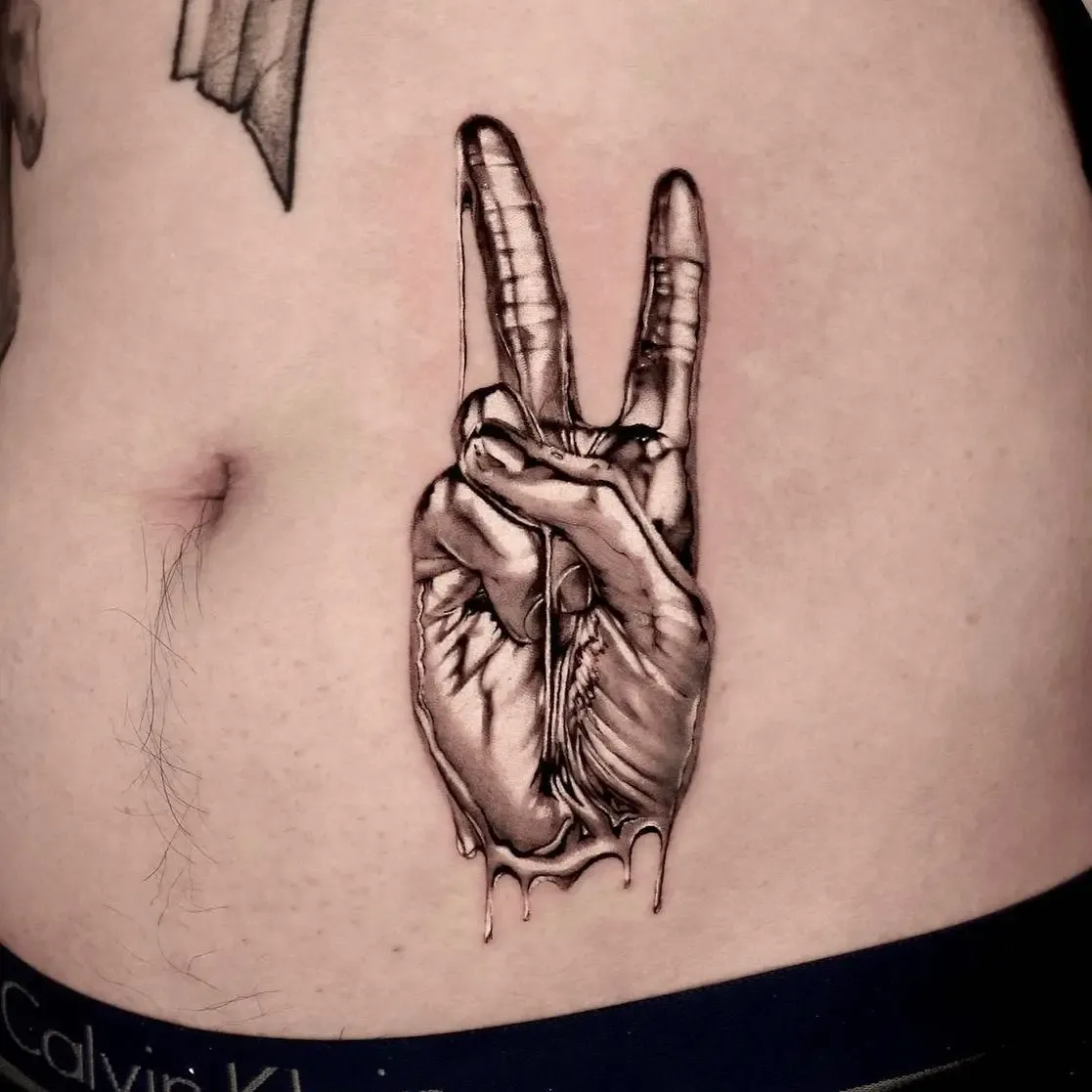 Abstraktes Tattoo: Peace-Hand aus flüssig glänzendem Chrom mit Tropfen auf dem Bauch