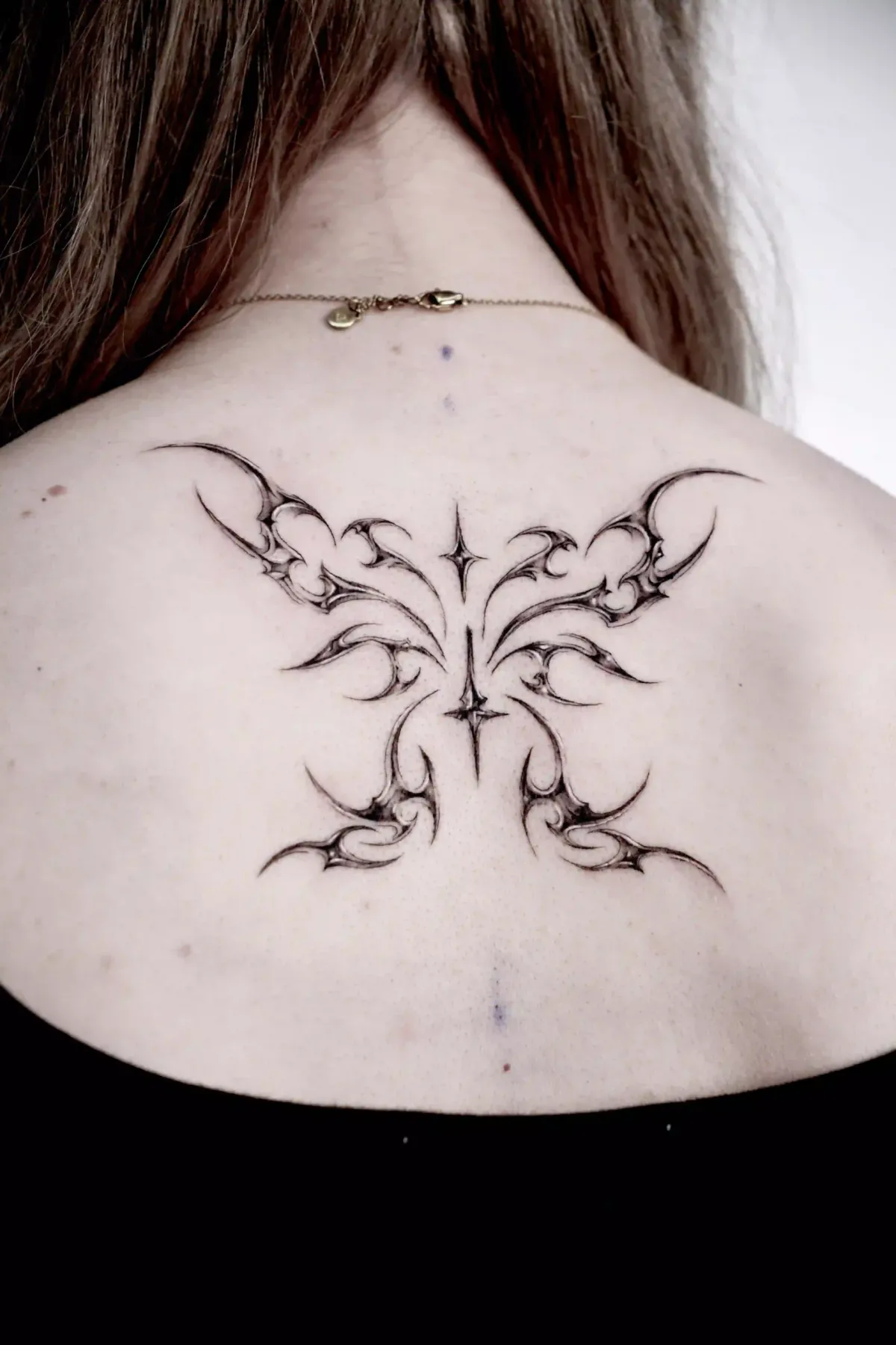 Cyber Sigilism Tattoo, symmetrisches Sigill aus feinen Klingen und Sternen, auf dem oberen Rücken