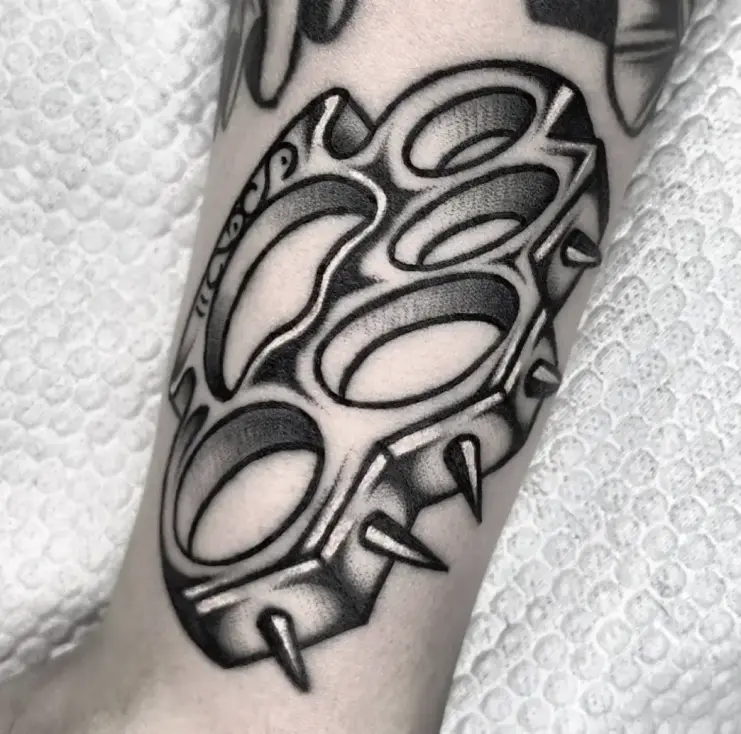 Traditional Tattoo, Schlagring mit Dornen in kräftigem Schwarz-Grau, auf dem Unterarm