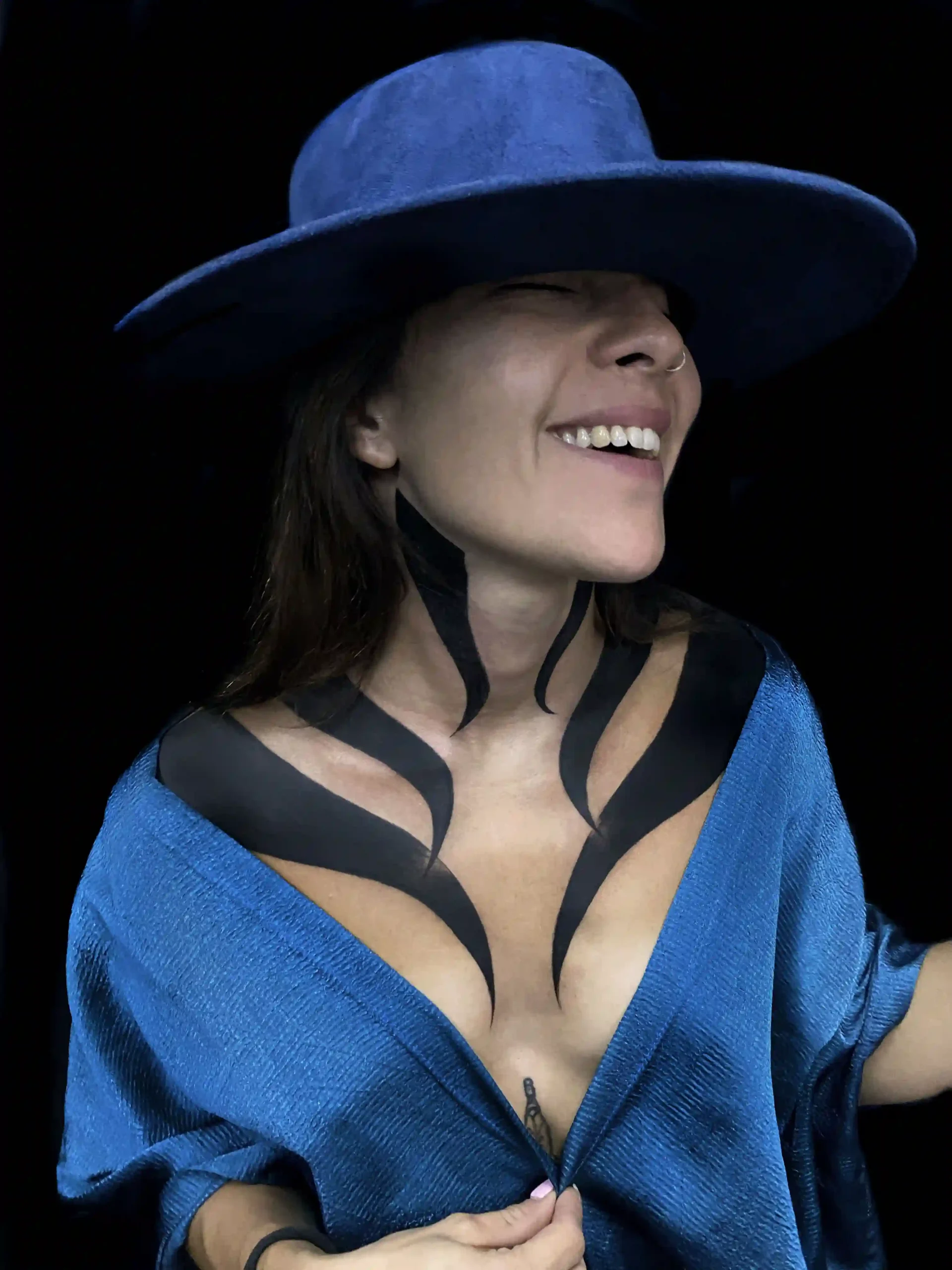 Dynamic blackwork tattoo flowing across neck and chest, combining movement and minimalism by Arturo.